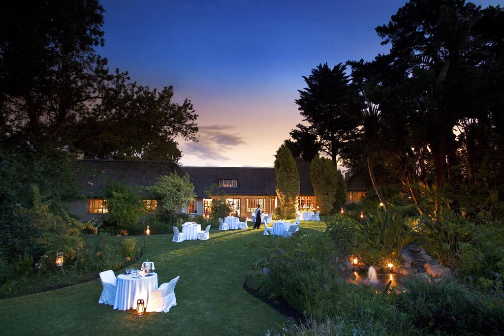 A large house with a lot of tables and chairs in front of it