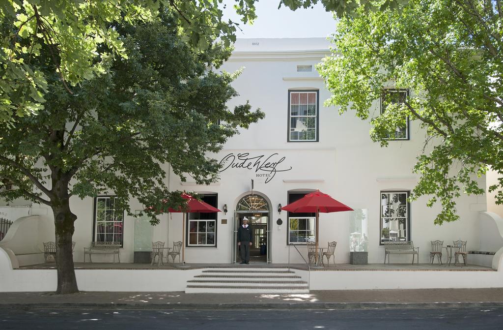 A white building with red umbrellas in front of it