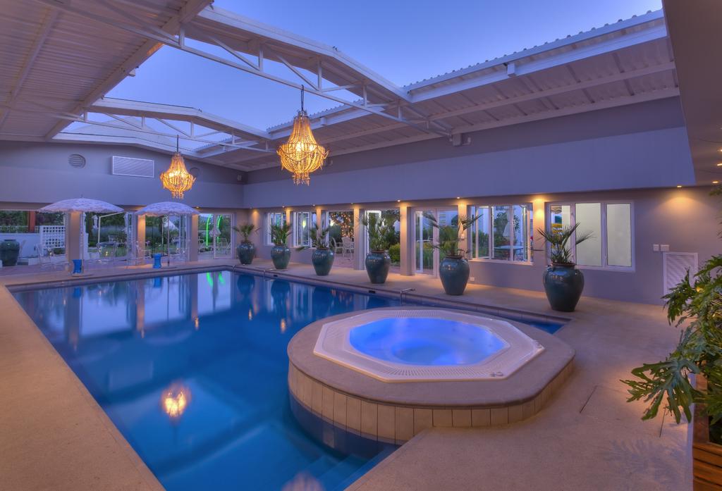 A large indoor swimming pool with a hot tub in the middle.