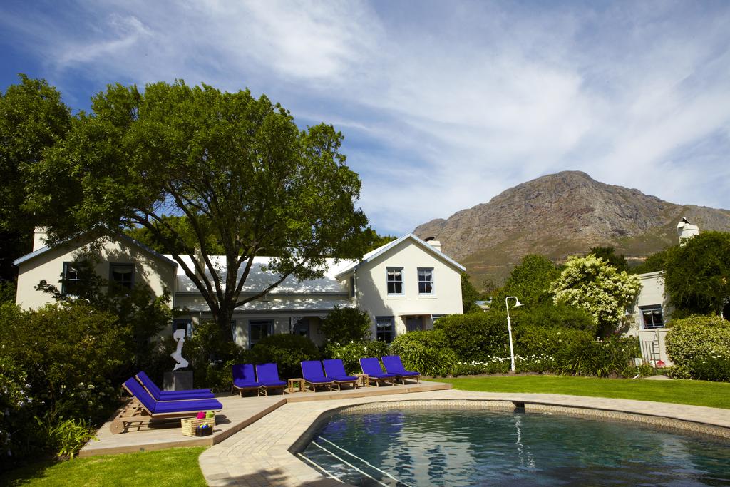 A swimming pool in front of a house with a mountain in the background