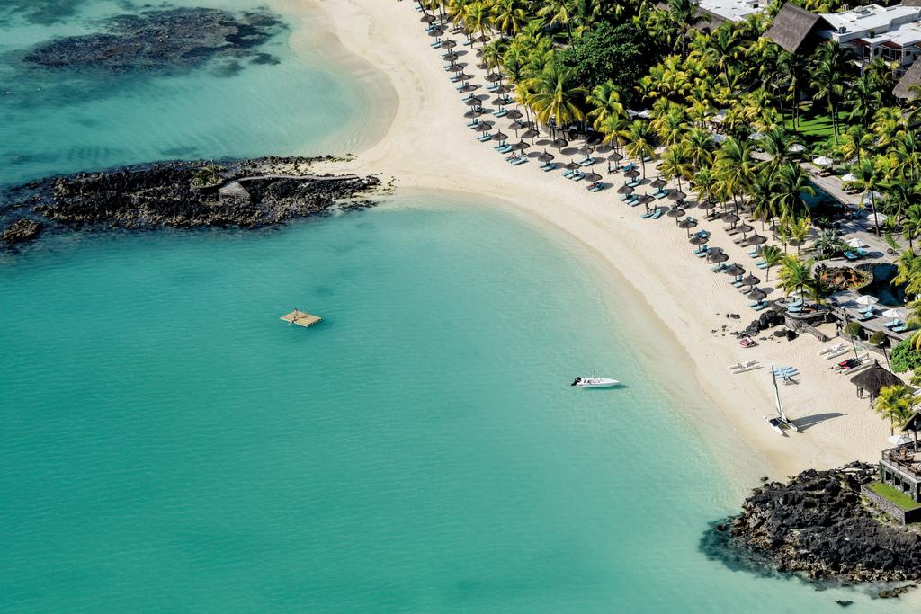 An aerial view of a beach with a boat in the water