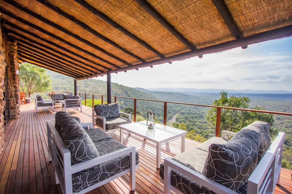 A wooden deck with a view of a forest and mountains.