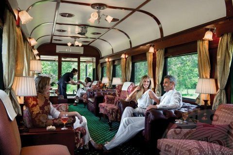 A group of people are sitting in a room on a train.