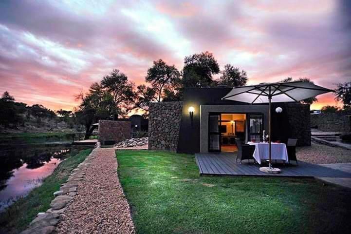 A house with a table and umbrella in front of it