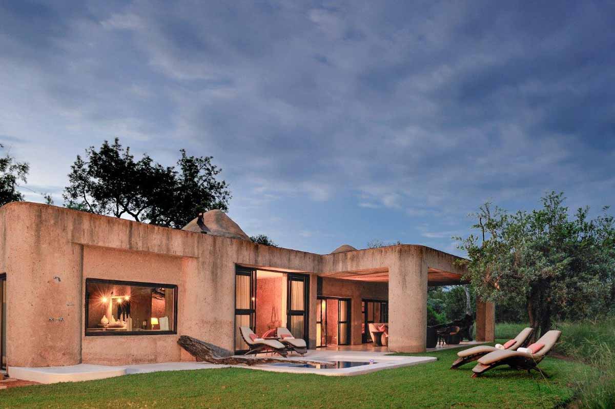 A house with a lot of windows and chairs in front of it