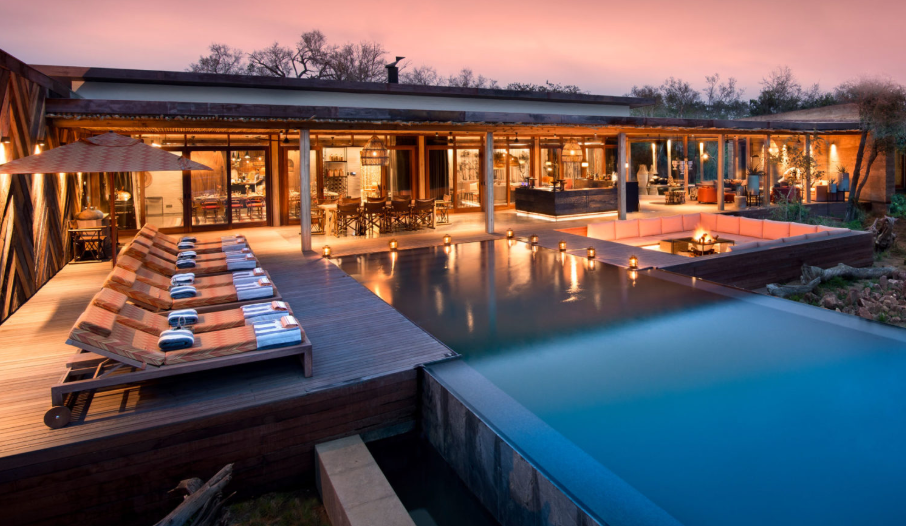 A large house with a swimming pool in front of it