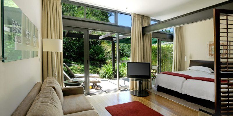 A hotel room with a couch a bed and a television