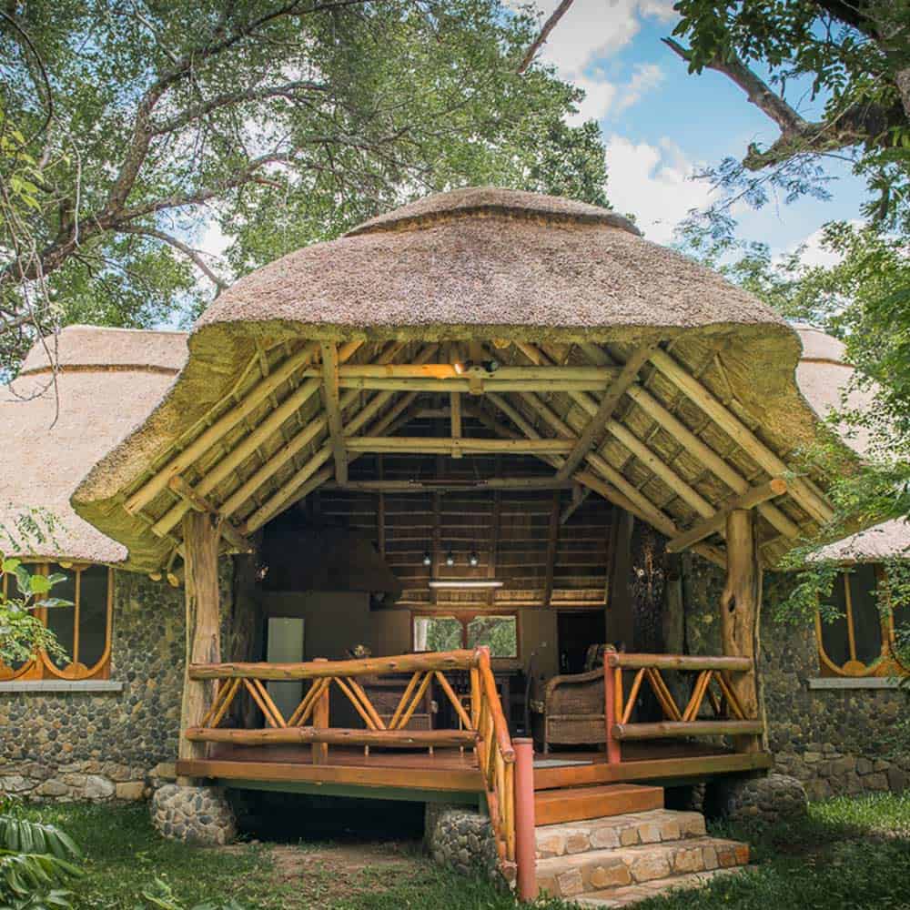 A house with a thatched roof and stairs leading to it