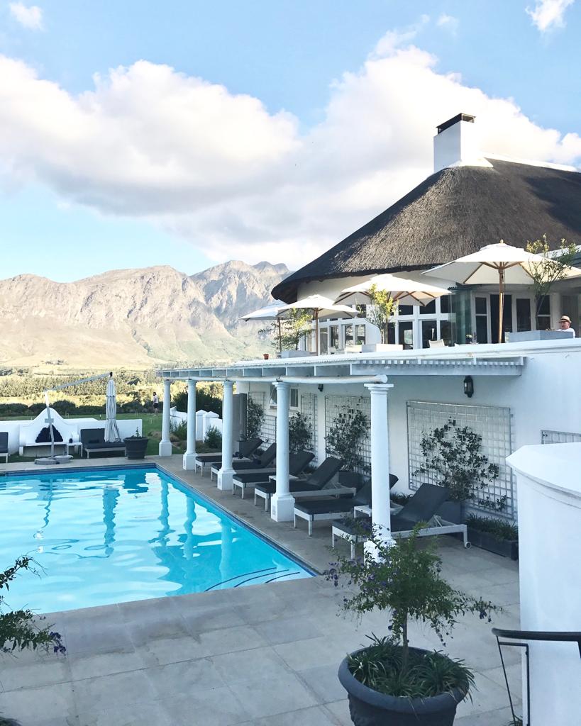 A large white house with a swimming pool in front of it