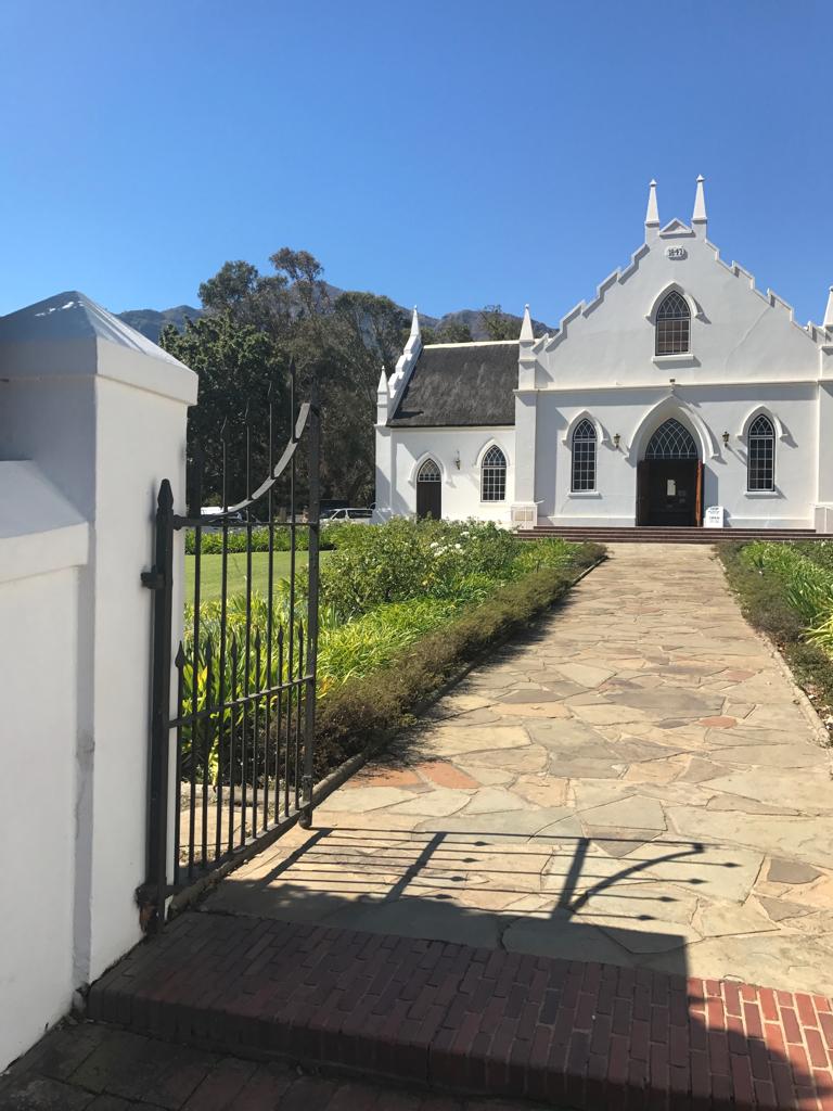 A white church with a brick walkway leading to it