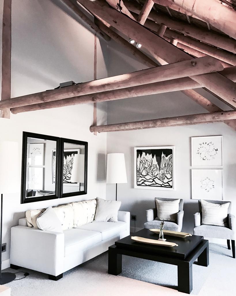 A living room with a white couch and chairs