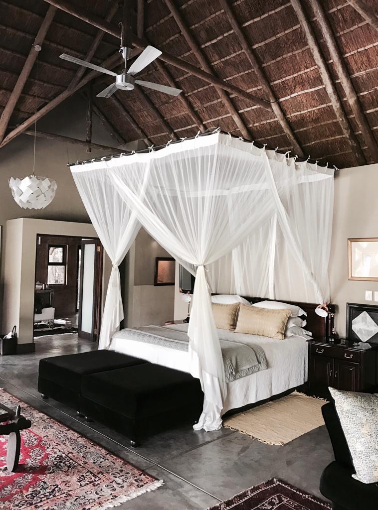 A bedroom with a canopy bed and a ceiling fan