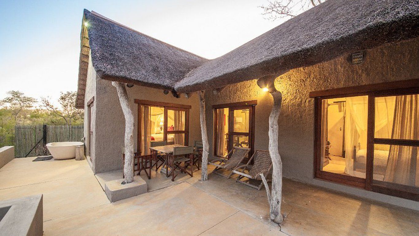 A large house with a thatched roof and a large porch.