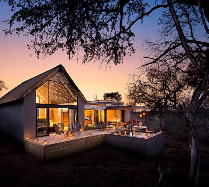 A house with a lot of windows is lit up at night