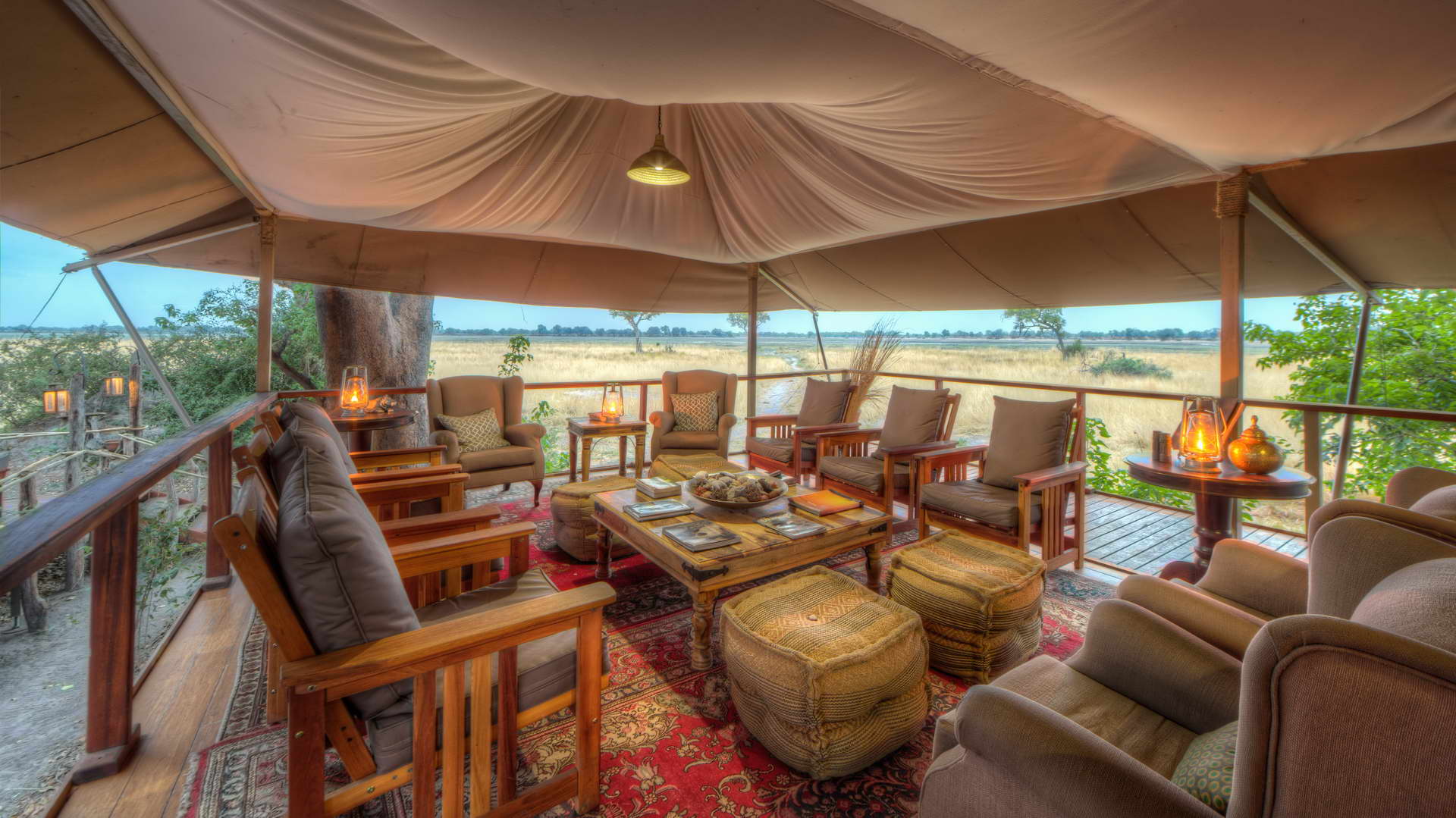 There are many chairs and tables under a tent.