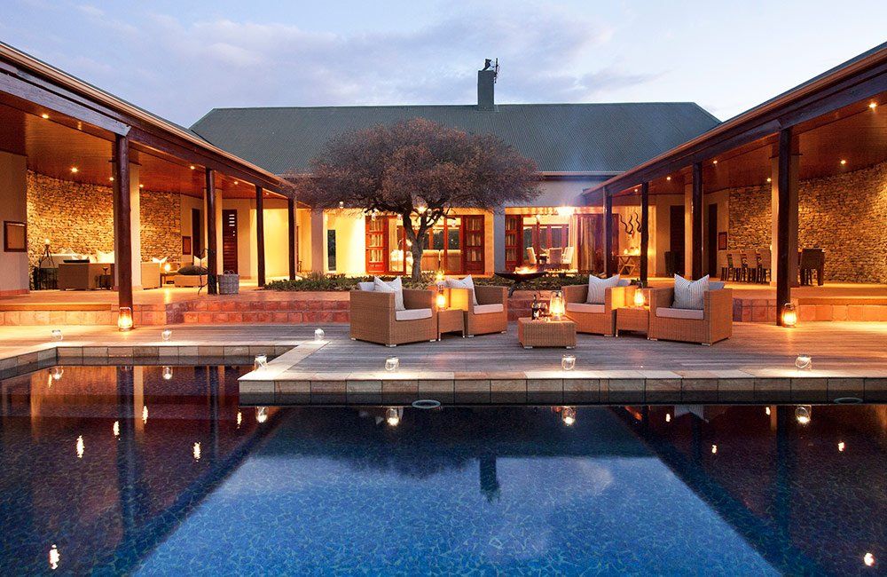 A large house with a swimming pool in front of it