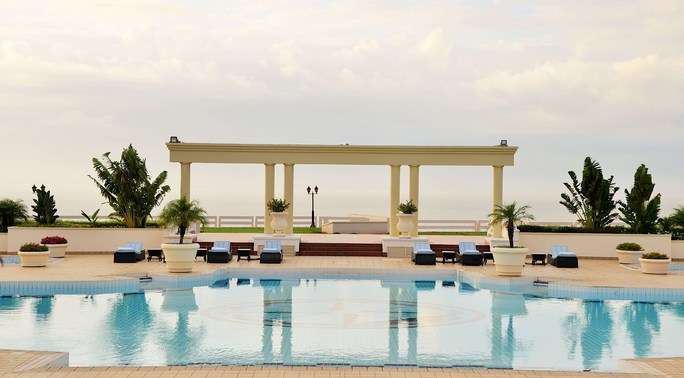 A large swimming pool with a gazebo in the background