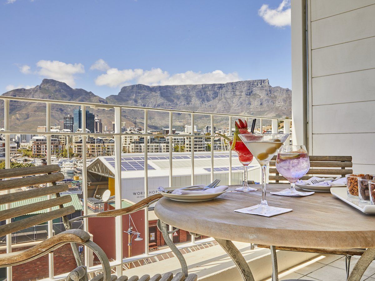 A table with two martini glasses on it with mountains in the background