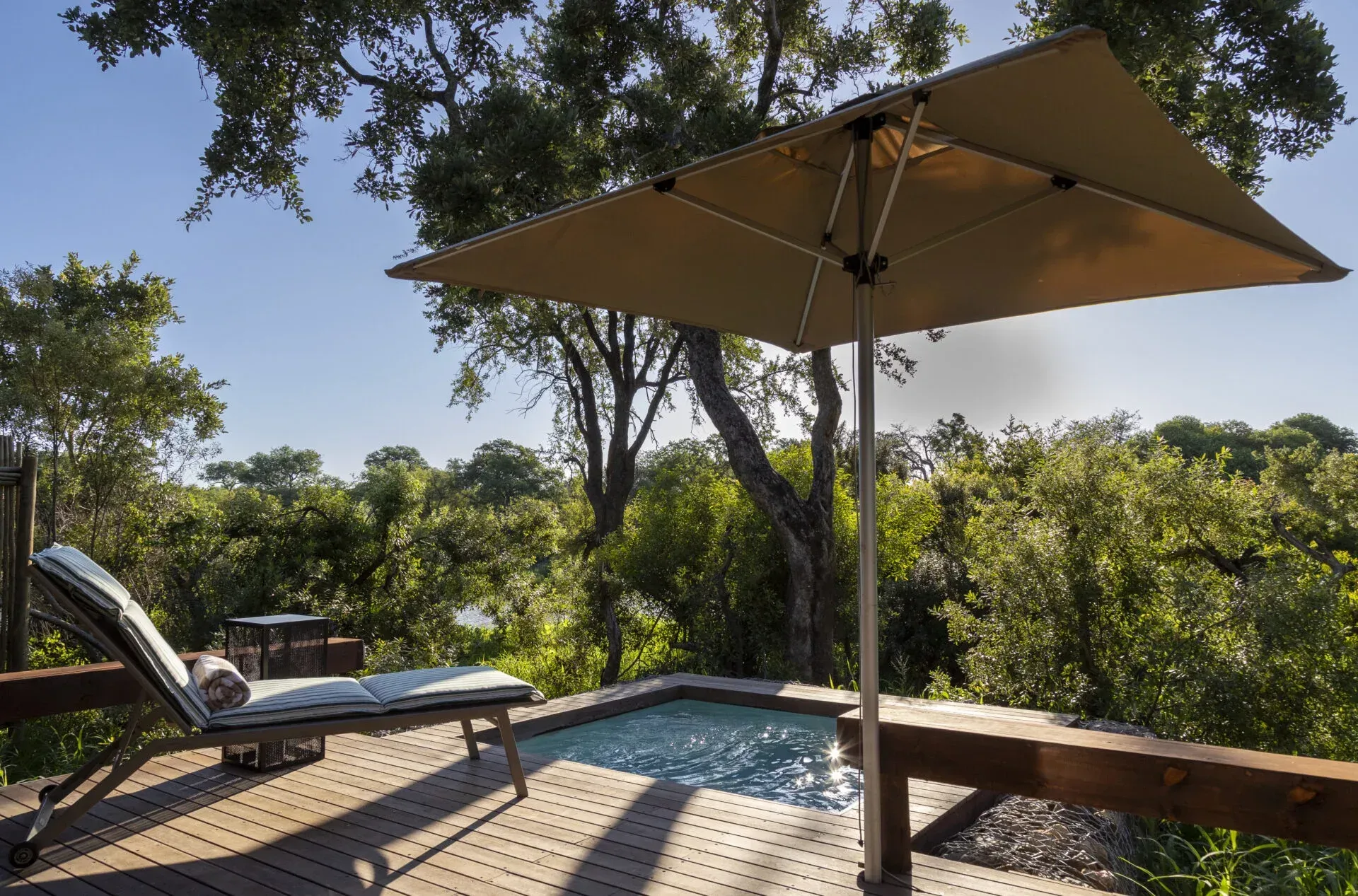 A swimming pool with a large umbrella over it