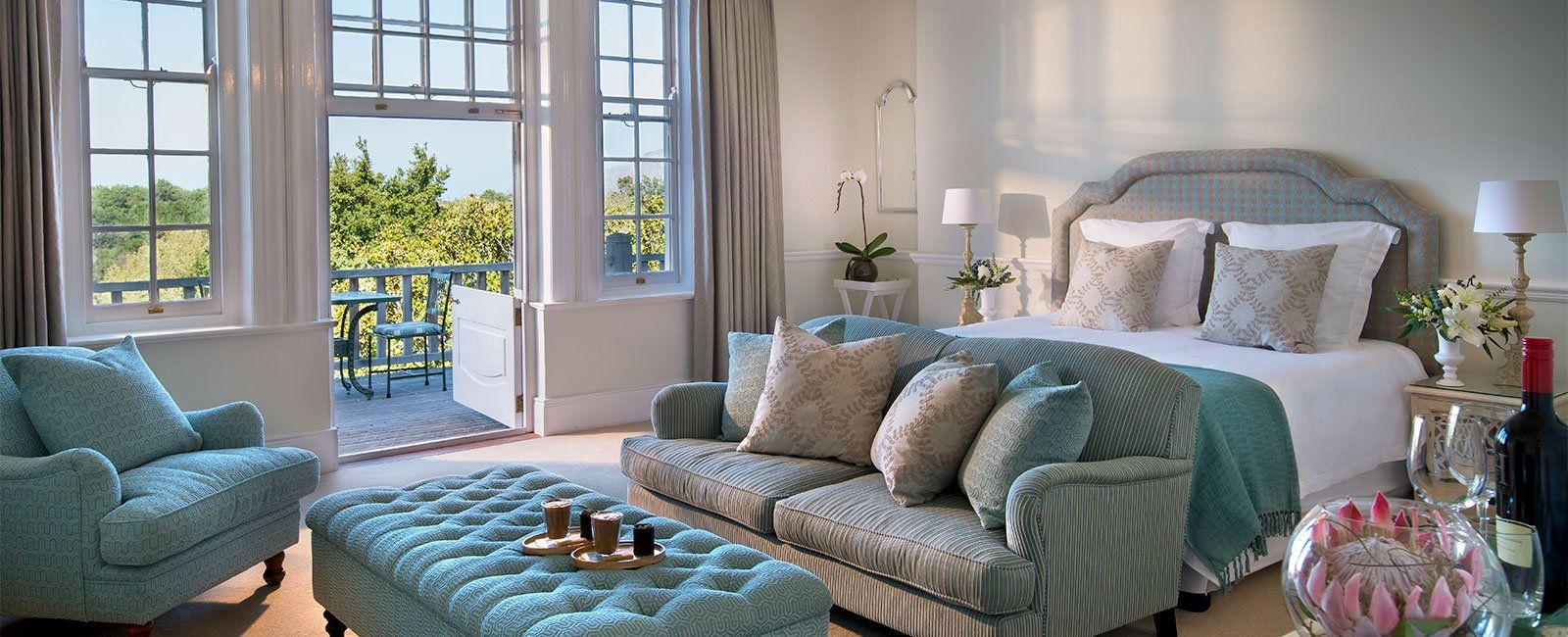 A bedroom with a bed , couch , chair and ottoman