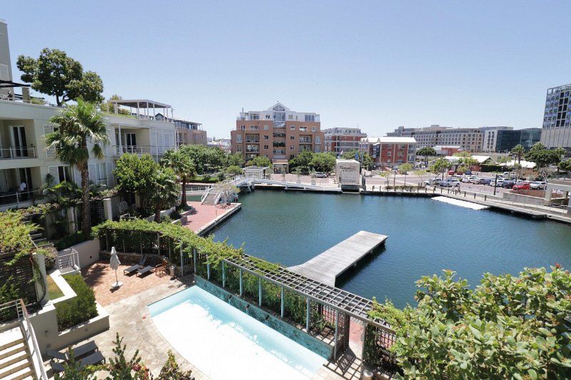 A large body of water surrounded by buildings and trees