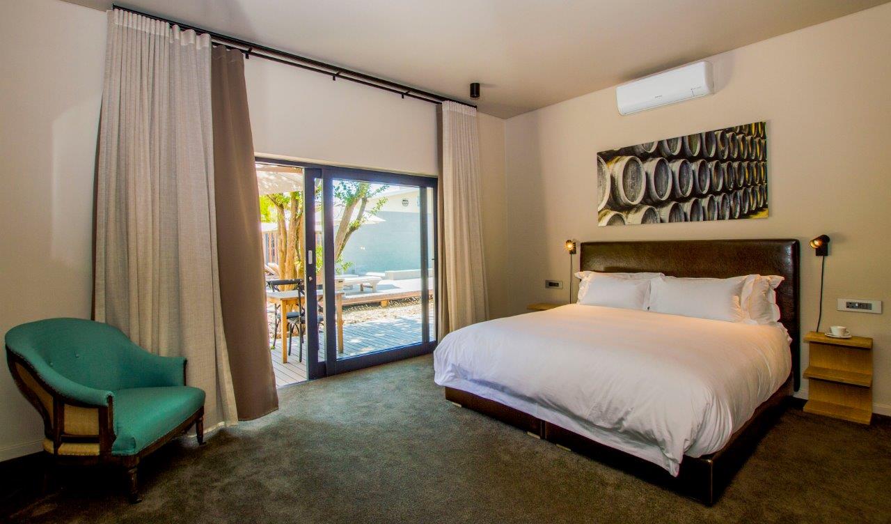 A hotel room with a king size bed and a chair.