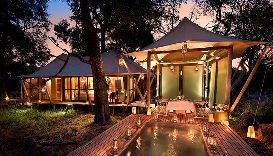 A large tent with a swimming pool in front of it