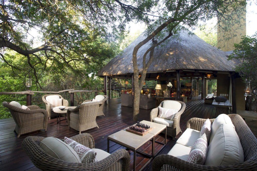 A patio with wicker furniture and a thatched roof