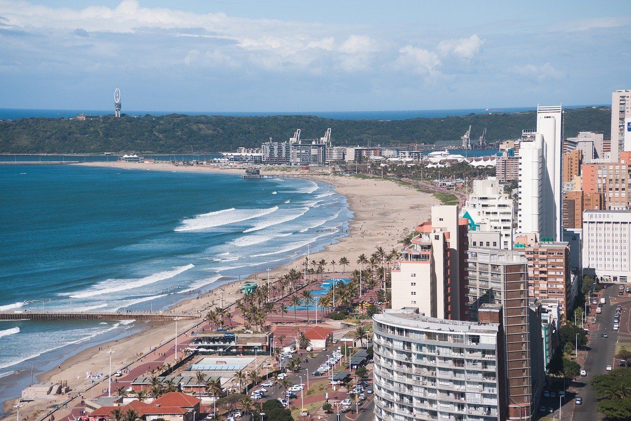 An aerial view of a city with a beach and ocean in the background.