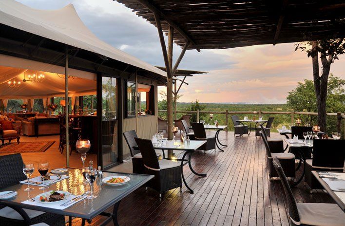 A restaurant with tables and chairs on a wooden deck