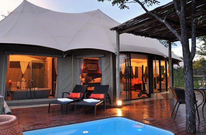 A tent with a swimming pool in front of it