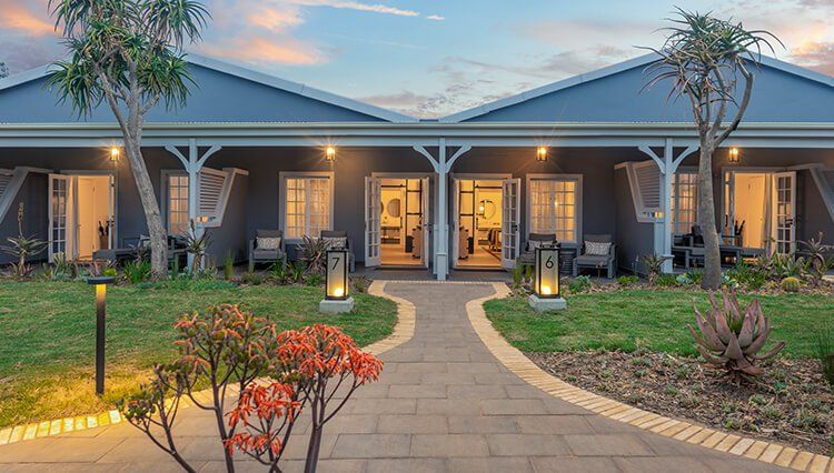 A large house with a lot of windows and a walkway leading to it.