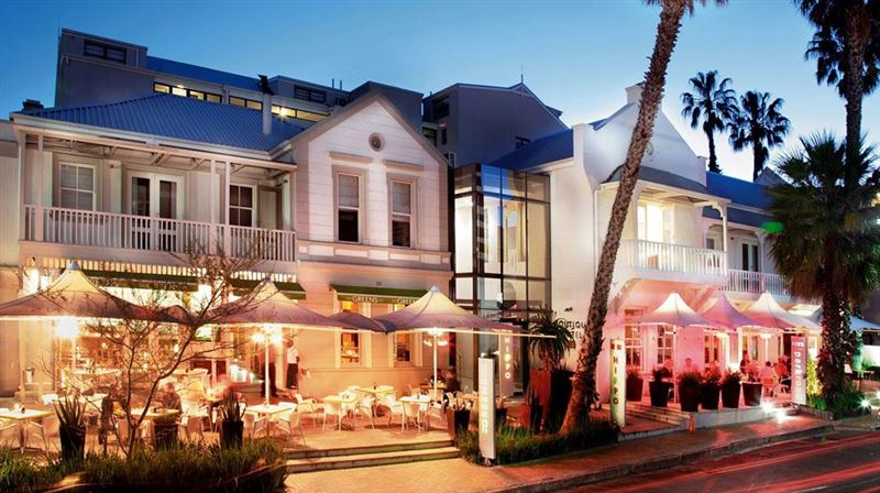 A large white building with palm trees in front of it