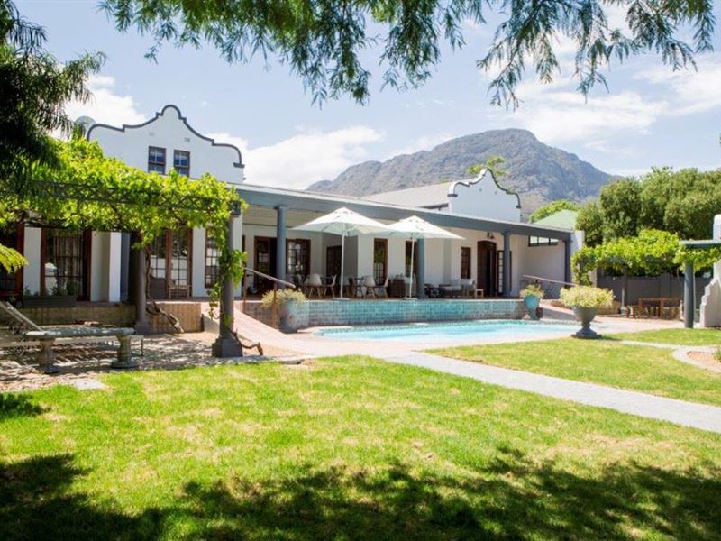 A large white house with a swimming pool in front of it