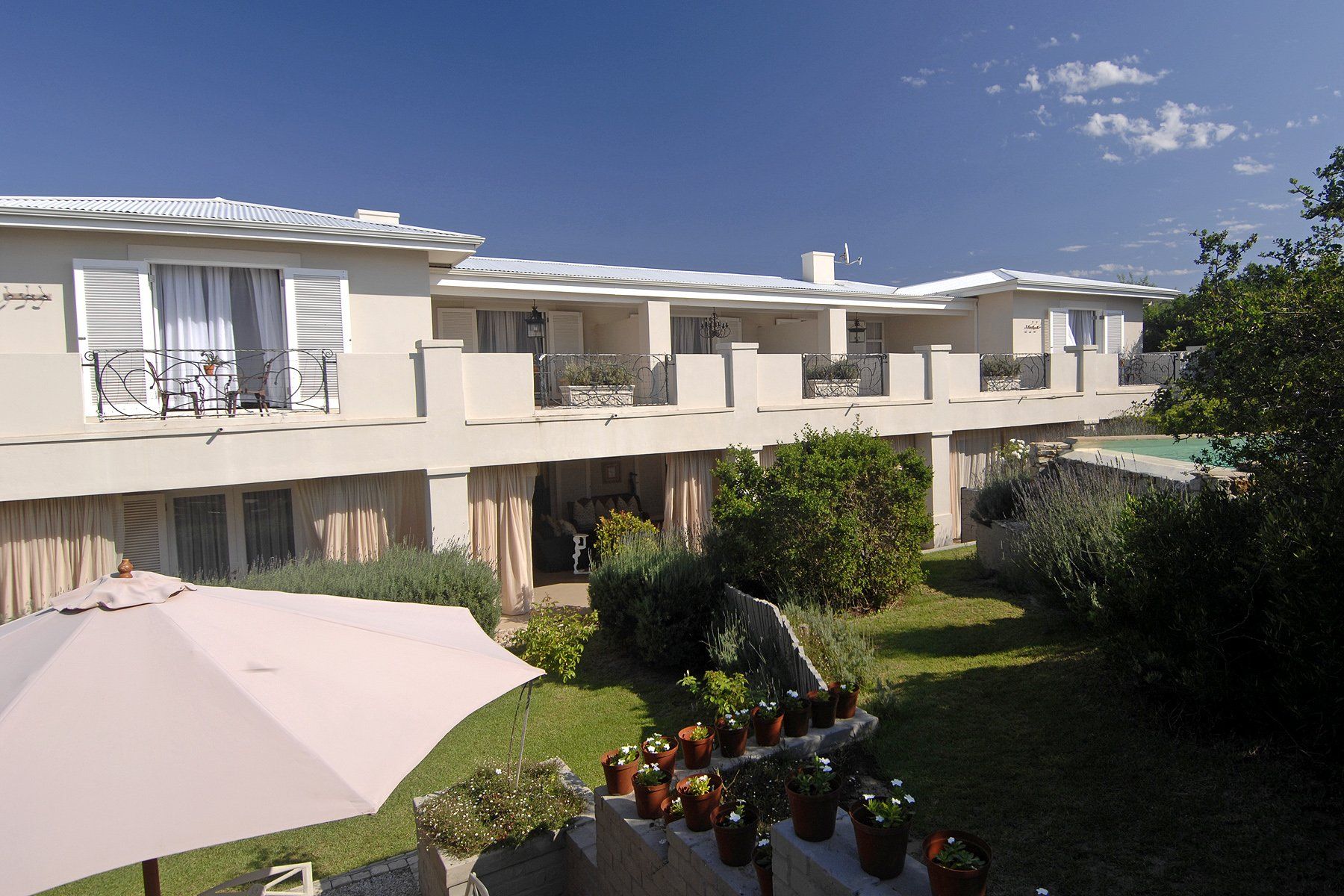 A large house with a lot of potted plants in front of it