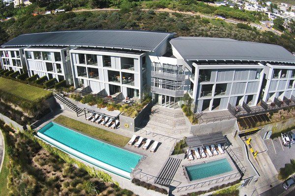 An aerial view of a large building with a swimming pool in front of it
