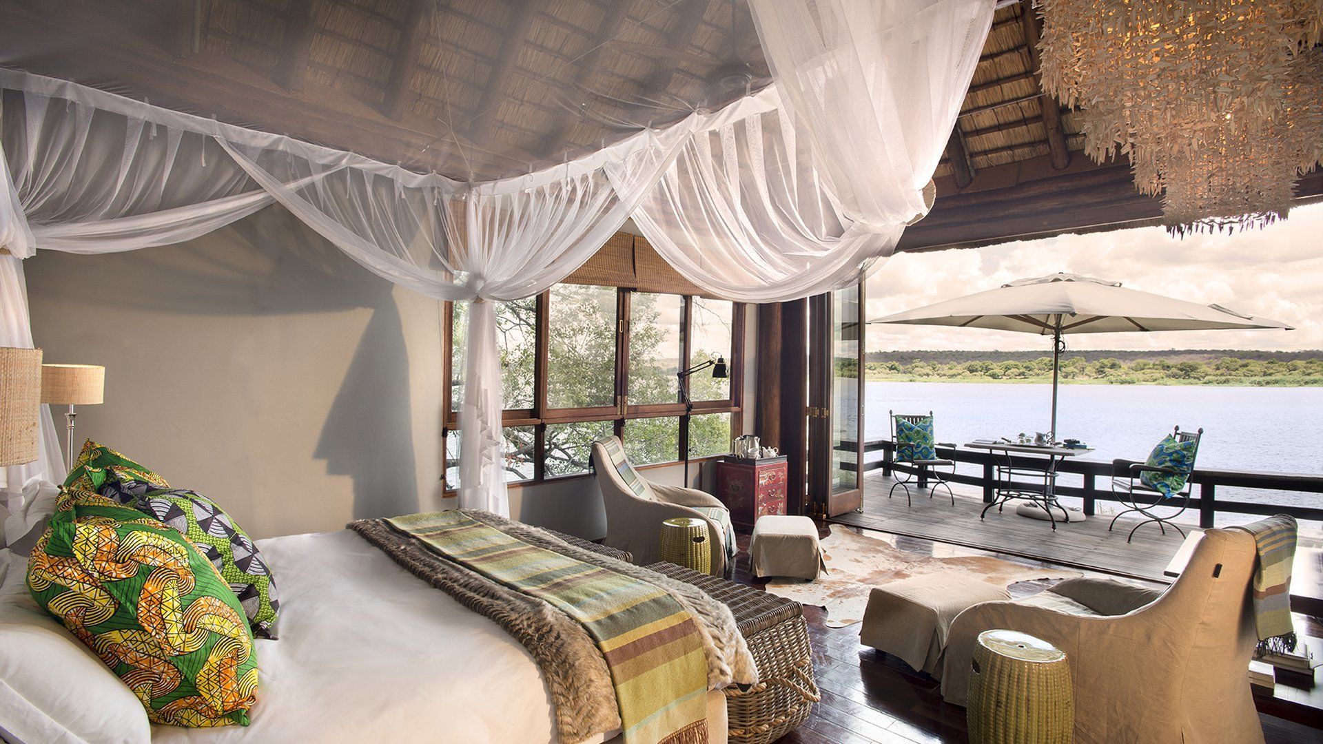 A bedroom with a canopy bed and a view of the water