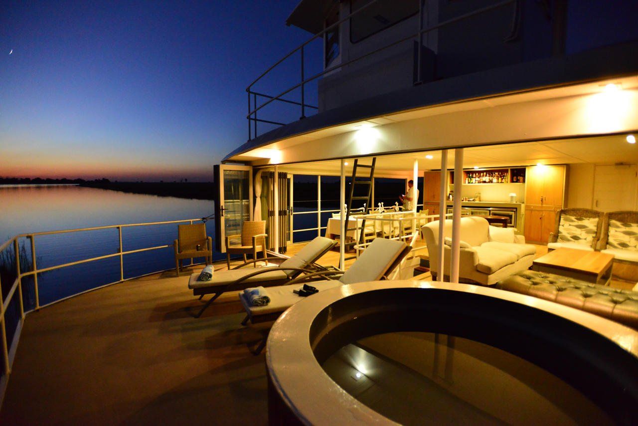 A boat with a hot tub on the deck at night