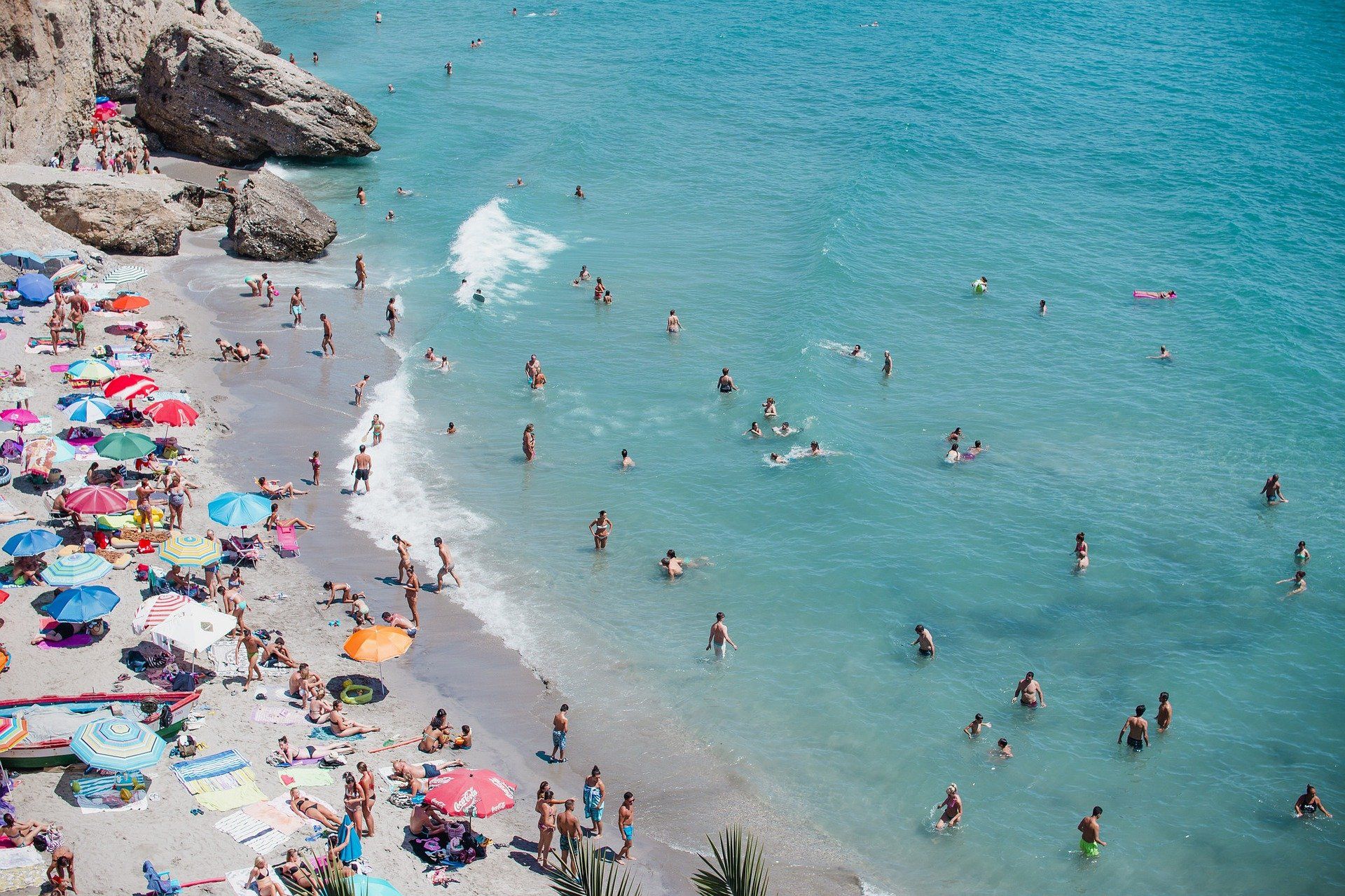 A group of people are swimming in the ocean on a beach.