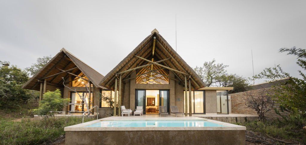 A large house with a swimming pool in front of it.