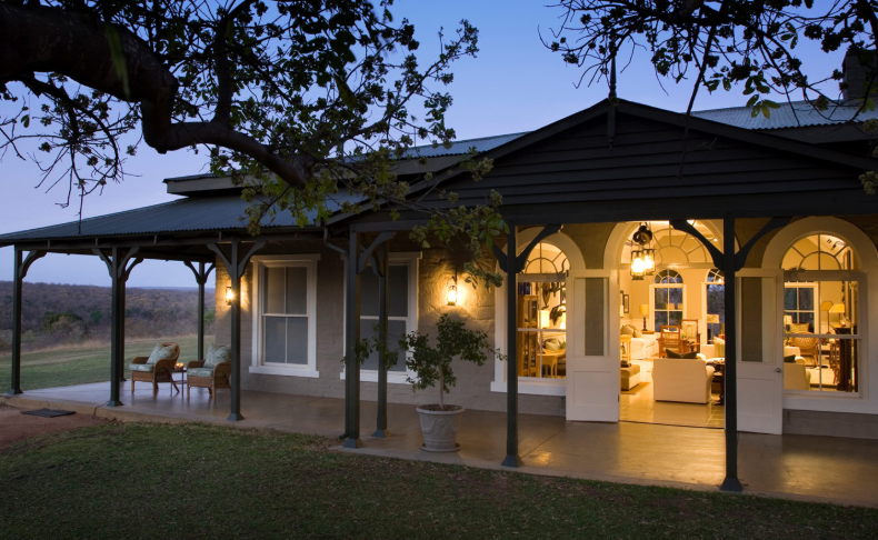 A house with a porch that is lit up at night