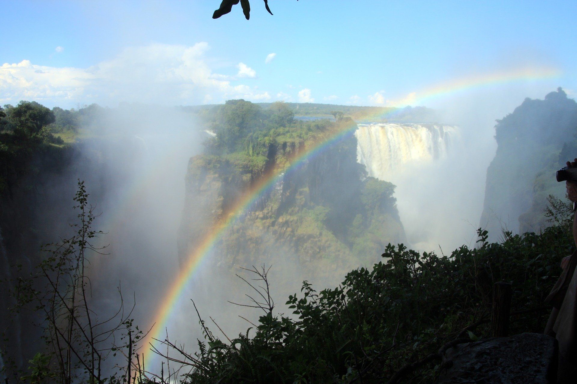 A waterfall with a rainbow in the background