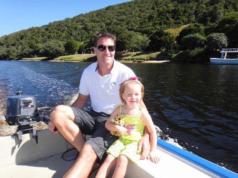 A man and a little girl are sitting on a boat