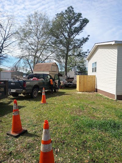 A truck is parked in a grassy yard next to a house.