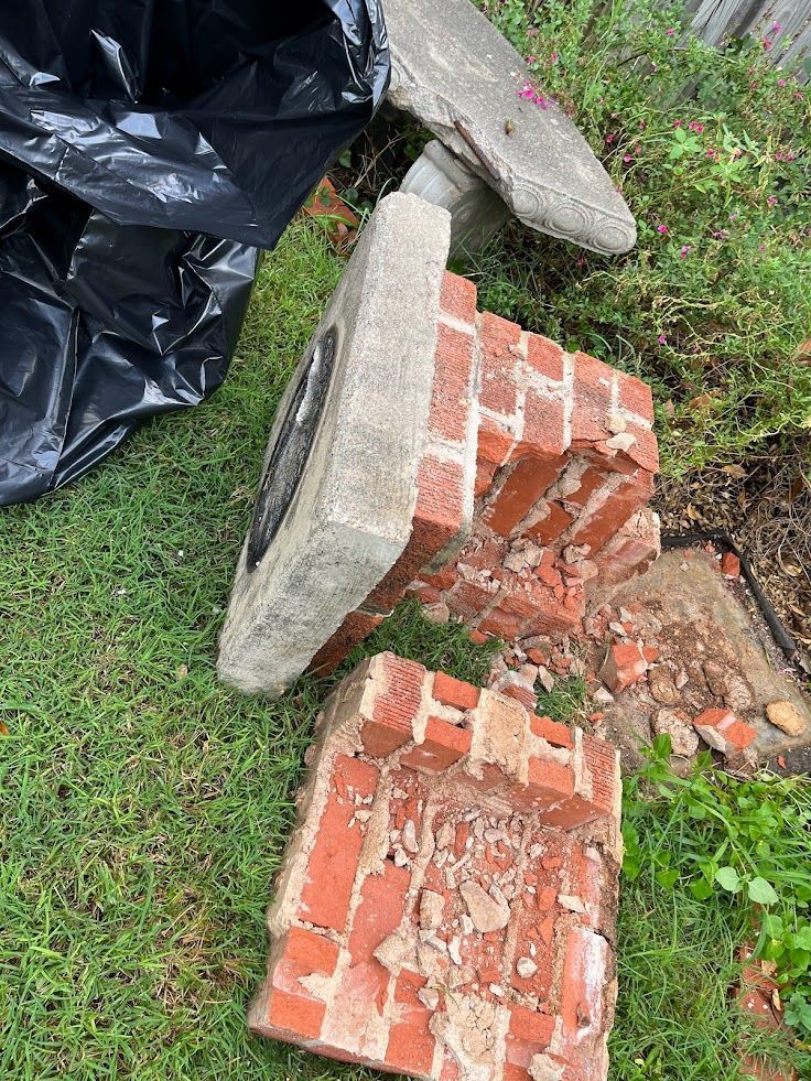 A pile of bricks and concrete sitting on top of a lush green field.