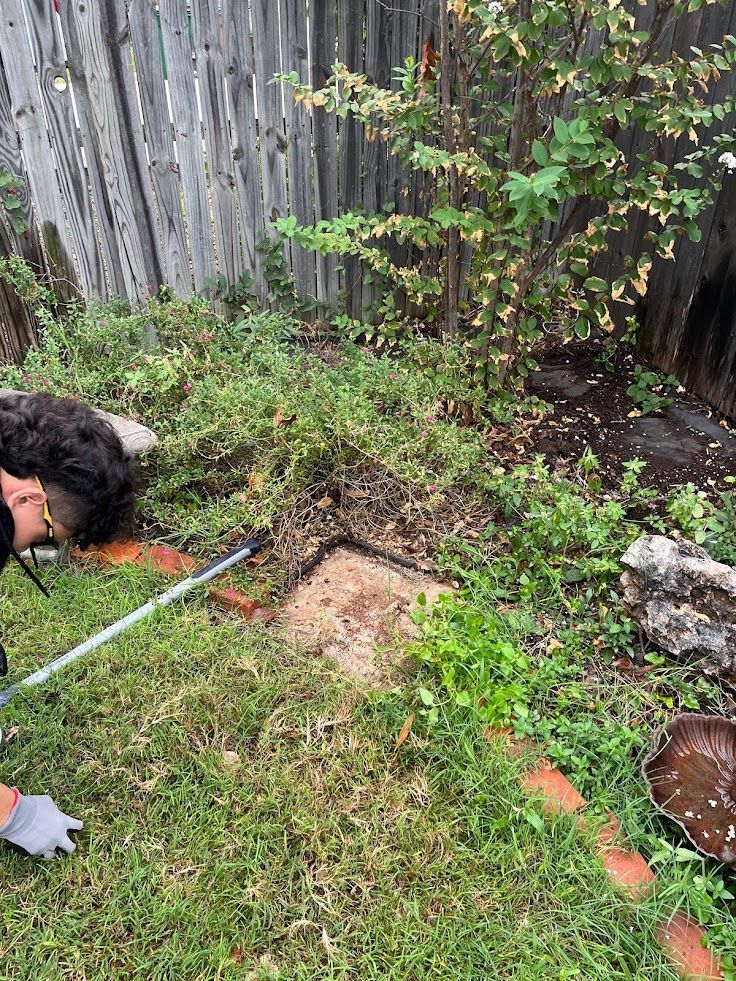 A person is laying in the grass with a shovel.