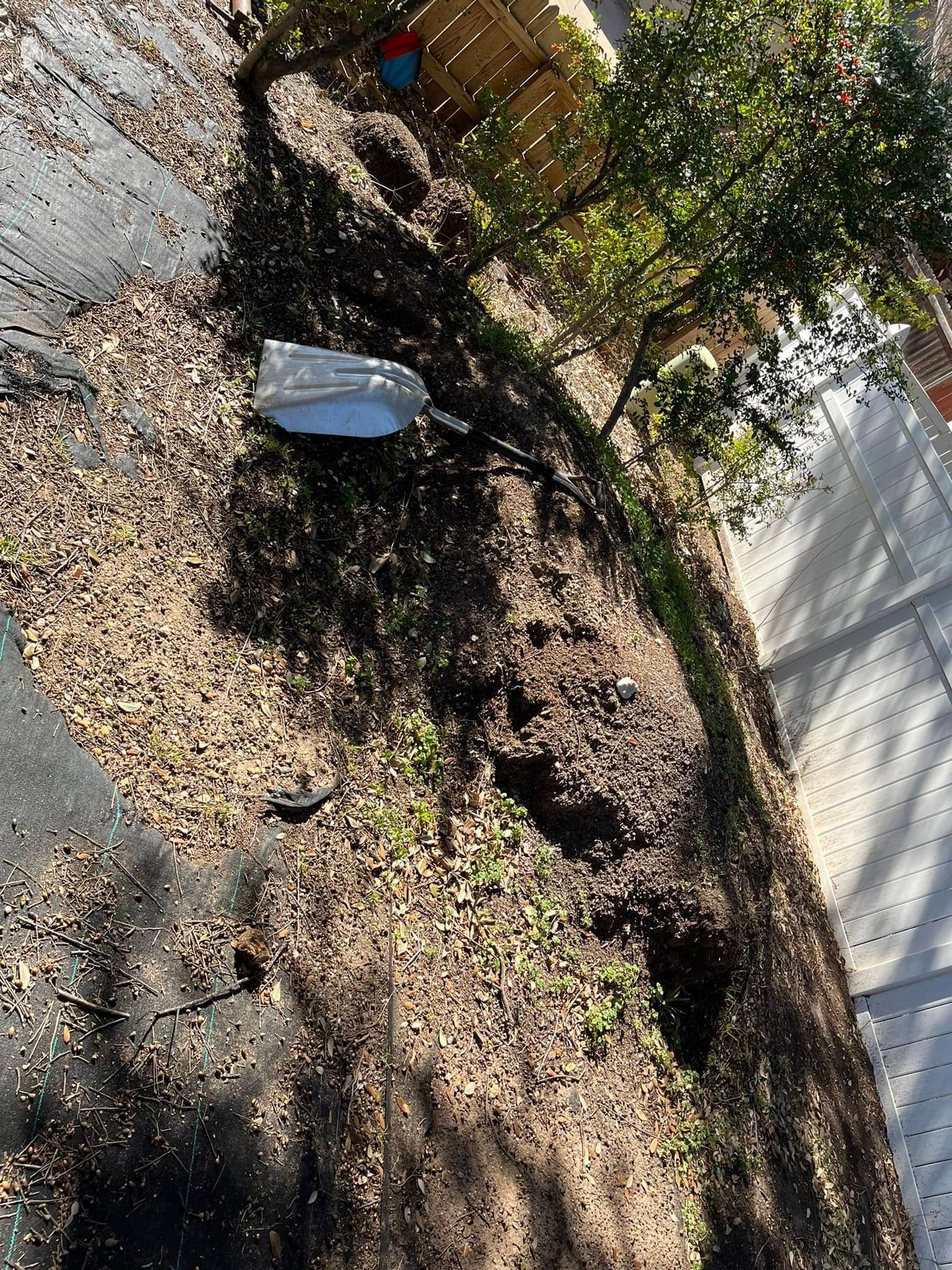 A pile of dirt is sitting on the side of a road next to a tree.