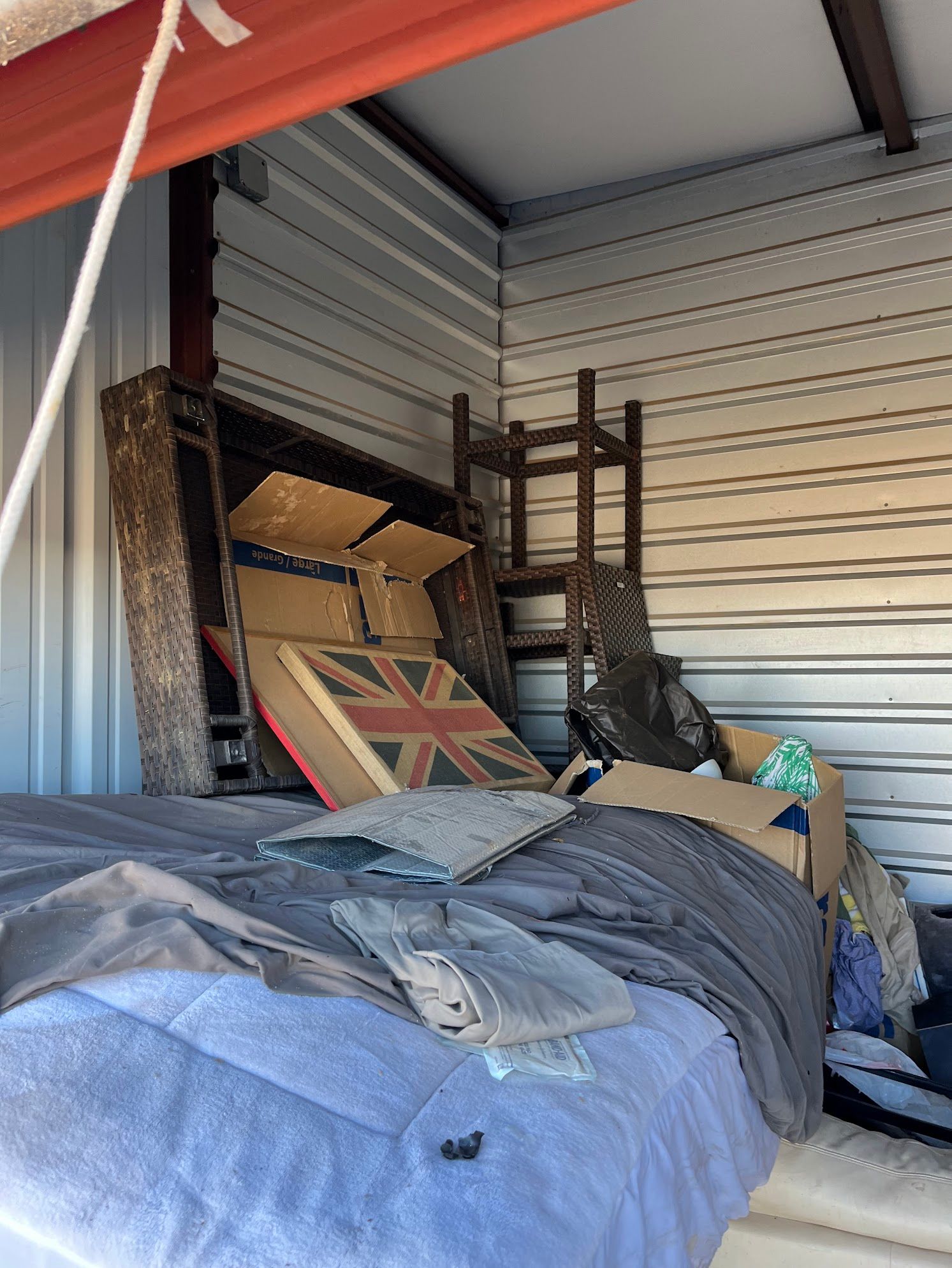 A room filled with lots of boxes and a bed.