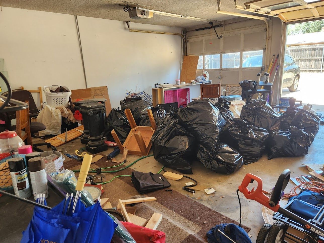 A garage filled with lots of trash bags and junk.