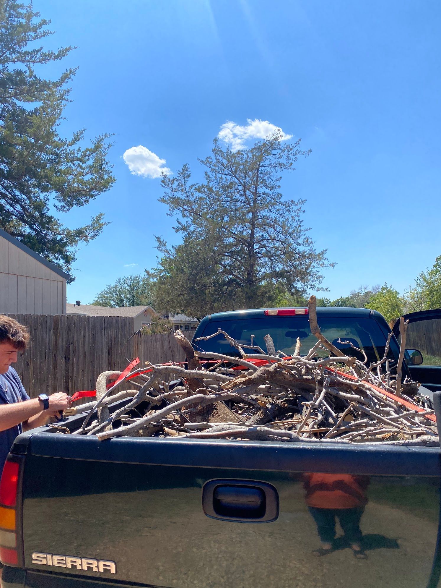 A man is loading wood into the back of a truck.